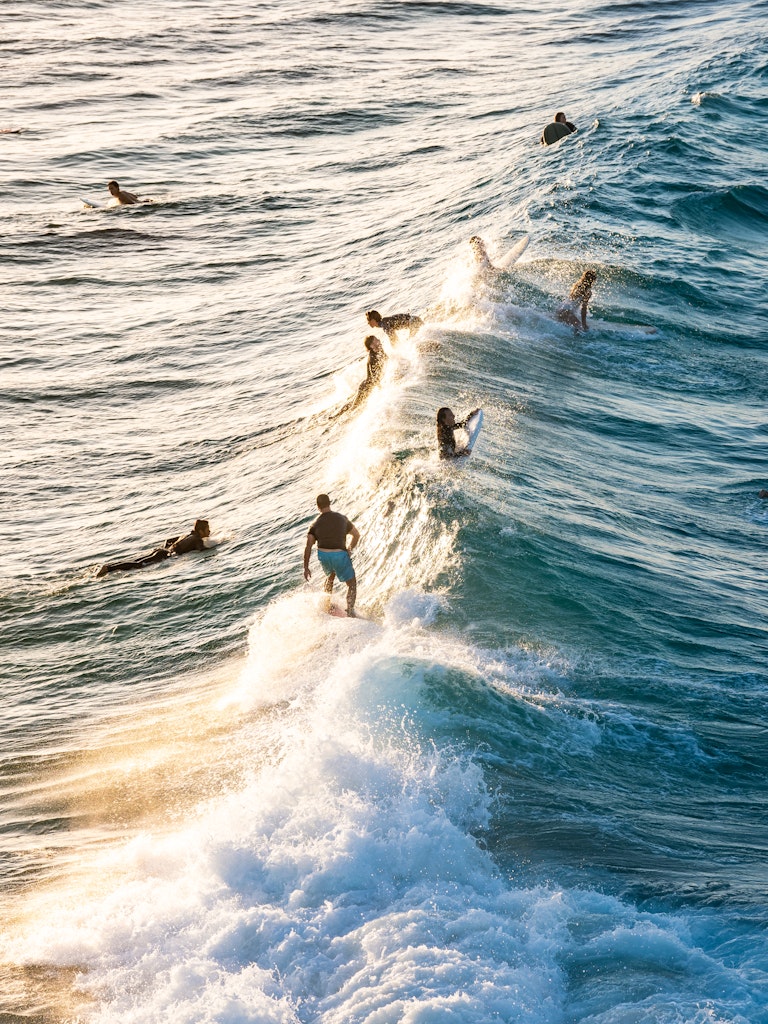 Byron Bay - Surfers on a Golden Wave - Surfers ride the waves on a golden afternoon at The Pass in Australia's Byron Bay.