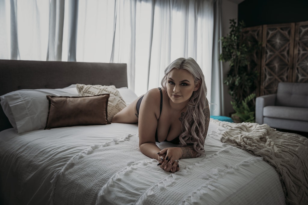 Boudoir Portfolio 48 - Stunning in studio boudoir session. Gorgeous blonde posing on the bed in black and red lingerie looking directly at camera. Self...