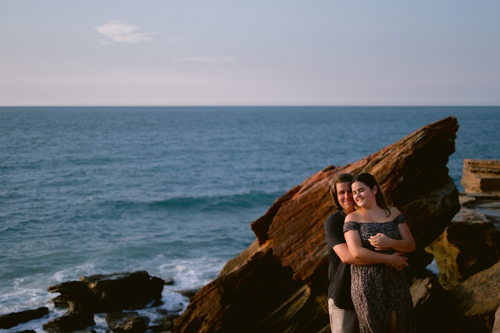 04 - Engaged couple holding each other during sunset overlooking the ocean in Broome, Western Australia.
